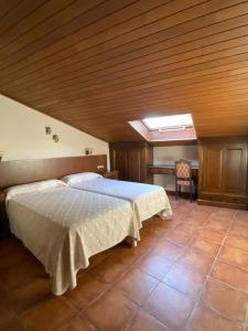 圣地亚哥－德孔波斯特拉Casa rural osvilares的一间卧室配有一张床和天窗