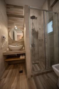尼基季Alios Gaia - Seaside Apartments的带淋浴、盥洗盆和镜子的浴室