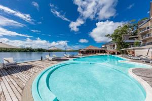 维拉港Ramada Resort by Wyndham Port Vila的一个带椅子和水的大型游泳池