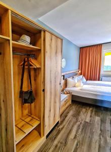 绍尔格鲁布AURA-HOTEL Saulgrub的小房间设有一张床和一个衣柜
