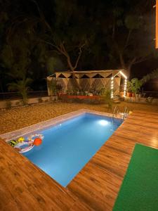 NānodraSuman Madhu Mansion的夜间游泳池,设有木甲板