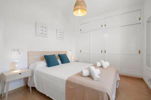 蓬塔普里马Punta Prima Apartments的白色卧室配有一张带蓝色枕头的大床