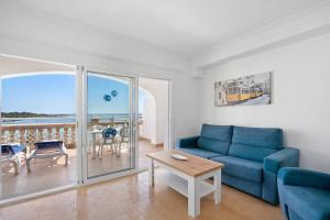 蓬塔普里马Punta Prima Apartments的客厅配有蓝色的沙发和桌子