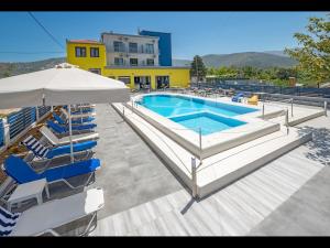 普利瑙港湾Thassian Riviera Hotel的一个带躺椅和遮阳伞的游泳池