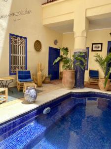 马拉喀什Riad Hotel Sherazade的一座带蓝色门的游泳池的房子