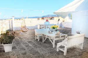 佩兹迪格雷科De Mola Holiday House的庭院配有桌椅和遮阳伞。