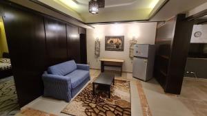 开罗The Resort Studio - New Cairo的客厅配有蓝色沙发和冰箱
