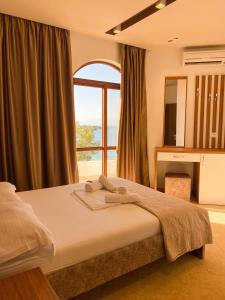 卡萨米尔Hotel Meta Ksamil的一间卧室设有一张床和一个大窗户