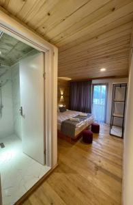 梅斯蒂亚Hotel Chubezeni的一间卧室设有一张床和一个玻璃淋浴间