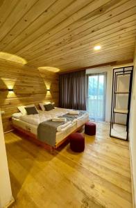 梅斯蒂亚Hotel Chubezeni的木制客房内的一间卧室配有一张大床