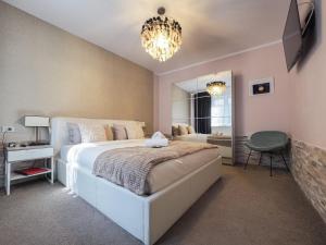 锡比乌For You Apartments Gold & Silver的一间卧室配有一张大床和一个吊灯。