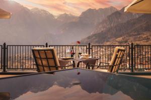 圣洛伦佐因巴纳莱Hotel Castel Mani的山景阳台上的桌椅