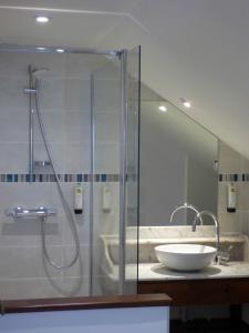 博让西Logis Hôtel La Tonnellerie的一间带玻璃淋浴和水槽的浴室