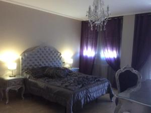 阿利坎特Hostal Mont Royal的一间卧室配有一张床、两张桌子和一个吊灯。