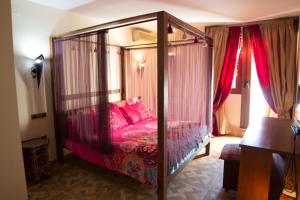 阿利坎特Hostal Mont Royal的卧室配有带粉红色枕头的天蓬床