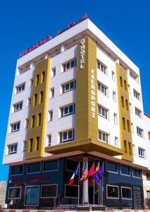 纳祖尔Hotel L'Aéroport的前面有旗帜的酒店大楼