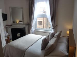 惠特比Lavinia House的卧室配有白色的床和窗户。