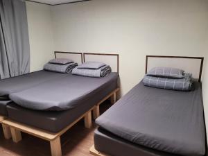 首尔弘大爱博宾馆的两张位于带喷雾器的房间的单人床