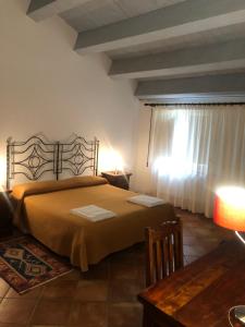 里波斯托托瑞阿奇拉度假酒店的一间卧室配有一张床、一张桌子和一个窗户。