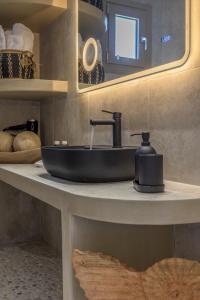 PachainaOcean Pearl Luxurious Suite的浴室设有黑色水槽和镜子