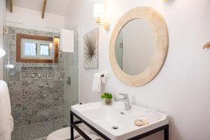 圣佩德罗苏拉Angeli Gardens Boutique Hotel的白色的浴室设有水槽和镜子