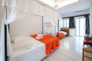 卡特瑞杜斯洛多斯酒店的一间卧室配有一张带橙色毯子的床