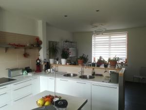 MontCarpe Diem的厨房配有白色橱柜、水槽和窗户。