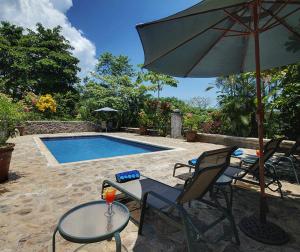 蓬塔雷纳斯Architectural home, Pool and High Speed Internet的一个带椅子和遮阳伞的庭院和一个游泳池