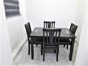 佩尼亚斯科港Santa Fé Apartamentos的一张黑色餐桌,配有四把椅子