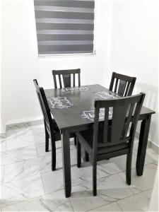 佩尼亚斯科港Santa Fé Apartamentos的一张黑色餐桌,配有两把椅子和窗户