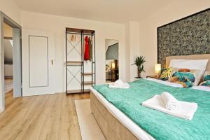 克雷费尔德NEAR MESSE! - Stay&Dream - 50qm - City - Kitchen - Netflix的一间卧室配有一张带两条白色毛巾的大型绿床