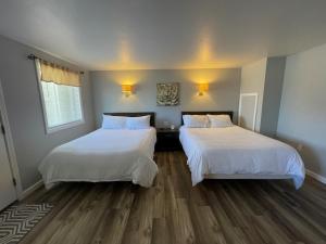 吉尔福特米斯蒂海港度假酒店的配有2张床的木地板客房