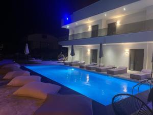 佩科霍里V luxury Suites的一座带椅子的游泳池,一座夜间建筑