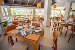 璜多里奥Coral Costa Caribe Beach Resort - All Inclusive的用餐室配有木桌和椅子