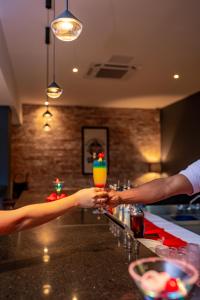 璜多里奥Coral Costa Caribe Beach Resort - All Inclusive的两个人在酒吧喝一杯