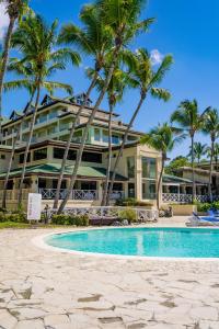 璜多里奥Coral Costa Caribe Beach Resort - All Inclusive的一个带游泳池和棕榈树的度假村