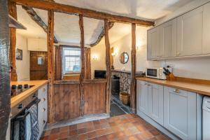 LindaleCragg Cottage的厨房配有白色橱柜和木门。