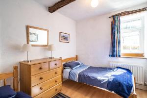 LindaleCragg Cottage的一间卧室设有两张床、一个梳妆台和窗户。