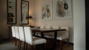 科伦坡Havelock Gardens BnB的一间带桌子和白色椅子的用餐室
