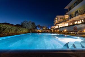 马尔切西内Wellness Hotel Casa Barca (Adult Only)的夜间大型蓝色游泳池