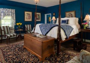 Zion CrossroadsProspect Hill Inn & Restaurant的一间卧室设有天蓬床和蓝色的墙壁。