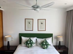 苏林海滩Beachfront 2 BR Luxury Condo Chava Surin的卧室配有白色的床和吊扇