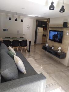 科尔多瓦Departamento 2 dormitorios Nueva Cordoba的客厅配有灰色的沙发和电视