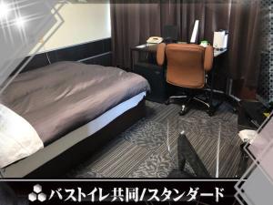 萨摩川内市商务住宿酒店的一间卧室配有一张床和一张带电脑的书桌