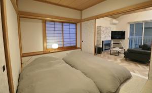 Futoスマートステイ大室山2合目的卧室内的一张大床,设有客厅