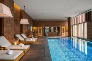 台北寒居酒店的酒店游泳池设有白色躺椅和游泳池
