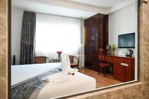 胡志明市TN Central Hotel的一间卧室配有一张带镜子的床
