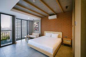 岘港SHI HOUSE by Haviland的卧室配有白色的床和砖墙