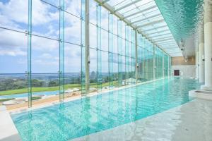 束草市Delpino的大型游泳池设有大型玻璃墙