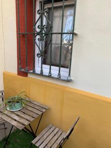赫雷斯-德拉弗龙特拉Mini Loft Plaza España的窗户、木制长凳、桌子和椅子